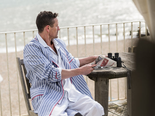 Model wearing a striped dressing gown over Budd white poplin pyjamas with navy piping